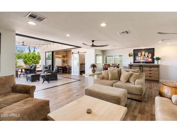 Open-concept living room featuring tile floors, neutral tones, plush seating, and access to the outdoor patio at 7510 E Larkspur Dr, Scottsdale, AZ 85260