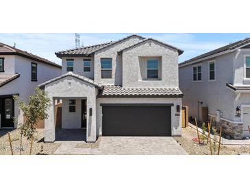 Stunning two-story home with a gray stucco facade, dark gray tiled roof and spacious two car garage at 8000 W Griswold Rd, Peoria, AZ 85345