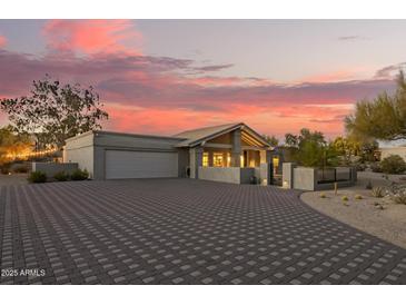 Beautiful home featuring neutral tones, a spacious driveway, desert landscaping, and a charming covered porch at 9432 E Quail Trl, Carefree, AZ 85377