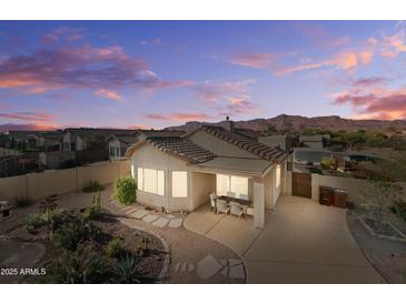 Desert backyard with dining and mountain views at dusk, showcasing outdoor living space at 10607 E Hillside Mine Ct, Gold Canyon, AZ 85118