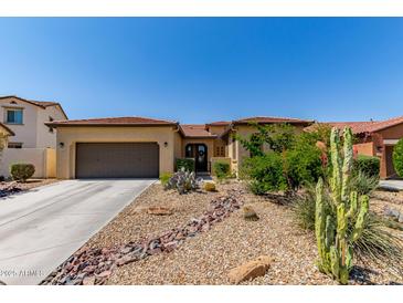 Charming single-story home features a desert-landscaped front yard with gravel and native plants at 17891 W Badger Way, Goodyear, AZ 85338