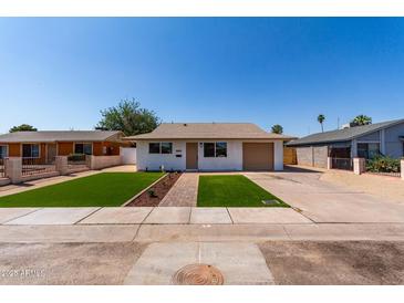 Charming single-story home featuring a well-manicured front yard and attached garage at 2443 E Randall Dr, Tempe, AZ 85288