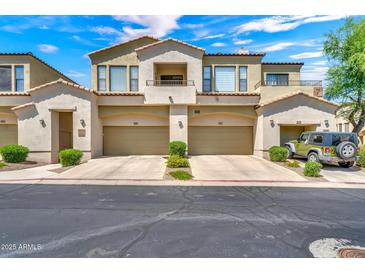 Charming townhome exterior with private garages and well-manicured landscaping under a sunny blue sky at 3131 E Legacy Dr # 1032, Phoenix, AZ 85042