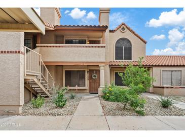 Inviting two-story condo with desert landscaping, a private balcony, and an attractive front door at 4901 E Kelton Ln # 1270, Scottsdale, AZ 85254