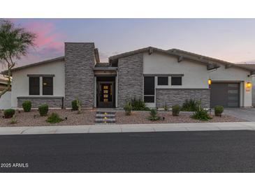 Charming single-story home showcasing stone accents, desert landscaping, and a two-car garage at 5218 N Tiller Dr, Litchfield Park, AZ 85340