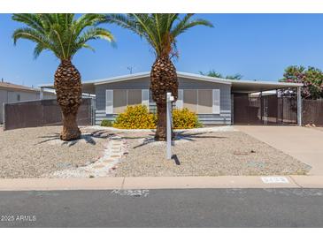 Charming single-story home featuring desert landscaping and mature palm trees, creating inviting curb appeal at 5436 E Aspen E Ave, Mesa, AZ 85206