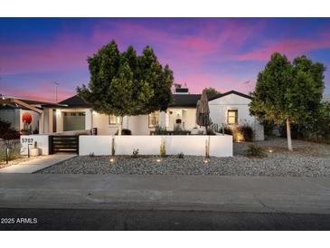 Charming home with modern landscaping, decorative wall, and trees providing curb appeal at 5707 N 12Th Pl, Phoenix, AZ 85014
