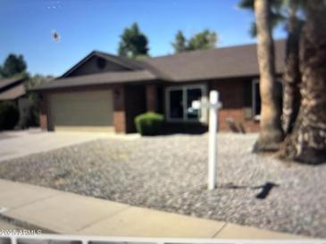 Charming single-story home with well-maintained landscaping, including gravel and mature trees at 6158 E Encanto St, Mesa, AZ 85205