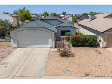 Charming single-story home with a two-car garage and low maintenance desert landscaping in front yard at 6938 W Nicolet Ave, Glendale, AZ 85303
