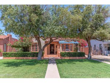 Charming front yard featuring lush green grass, mature trees and a well-maintained landscape at 1134 W Portland St, Phoenix, AZ 85007