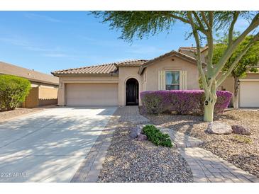 Charming single-story home featuring a well-manicured landscape, paver walkway and a two-car garage at 12118 W Dove Wing Way, Peoria, AZ 85383