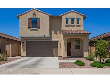 Charming two-story home featuring neutral stucco, a two-car garage, and a well-manicured front yard at 14180 W Willow Ave, Surprise, AZ 85379