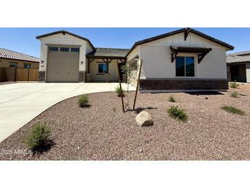 Charming single-story home features a neutral exterior with stone accents, a two-car garage, and low-maintenance landscaping at 17324 W Royal Palm Rd, Waddell, AZ 85355
