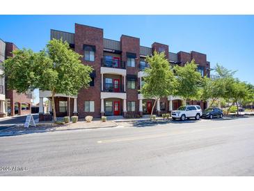 Multi-story building with red brick and small balconies with mature trees in front at 475 N 9Th St # 303, Phoenix, AZ 85006