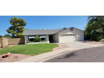 Charming one-story home with a well-maintained lawn, attached garage, and inviting curb appeal at 949 N Ricardo N Cir, Mesa, AZ 85205