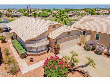 Charming home featuring a two-car garage, meticulous landscaping and a tile roof at 10526 W Tonopah Dr, Peoria, AZ 85382