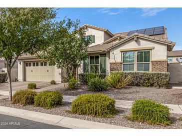 Charming single-Gathering home boasts well-maintained landscaping and a two-car garage, enhanced by solar panels on the roof at 10718 E Vivid Ave, Mesa, AZ 85212
