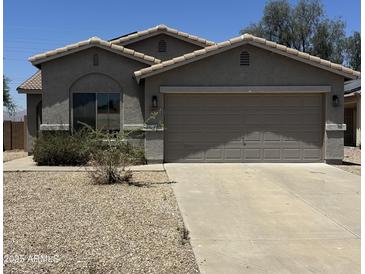 Charming single-story home with a two-car garage and low maintenance desert landscaping at 14038 N 162Nd Ln, Surprise, AZ 85379