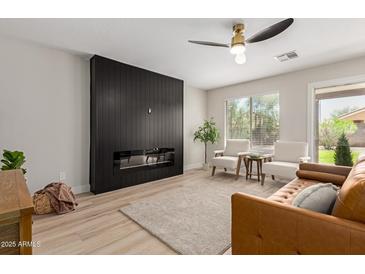 Bright living room with a modern fireplace, neutral color palette, ceiling fan, and comfortable seating at 33287 N Windmill Run, San Tan Valley, AZ 85144