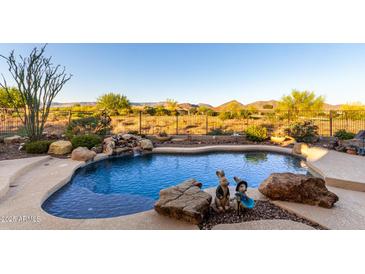 Beautiful backyard pool with rock waterfall feature and desert views in a private setting at 40619 N Candlewyck Ln, Phoenix, AZ 85086