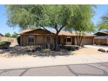 Charming single-story brick home featuring mature shade trees and a low maintenance front yard at 4516 E Willow Ave, Phoenix, AZ 85032