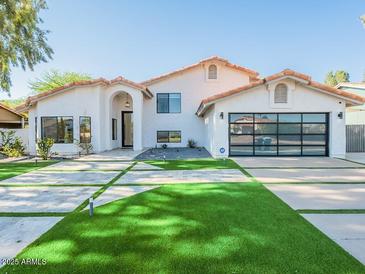 Beautiful modern home with a well-manicured front yard and a spacious glass garage door at 4748 E Redfield Rd, Phoenix, AZ 85032