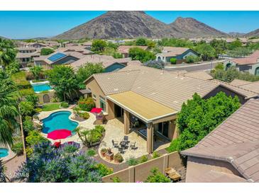 An inviting backyard featuring a sparkling pool, covered patio, and lush landscaping in a desert community at 4935 W Lariat Ln, Phoenix, AZ 85083