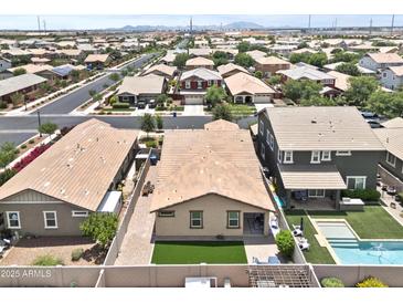 An aerial view shows a neighborhood with well-maintained homes, green lawns and a community pool at 7440 E Osage Ave, Mesa, AZ 85212