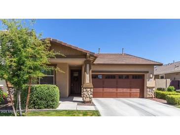 Charming single-story home with well-maintained landscaping and a two-car garage at 7440 E Osage Ave, Mesa, AZ 85212