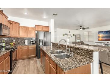 Open kitchen featuring granite countertops, stainless appliances, and a breakfast bar at 8209 S 23Rd Pl, Phoenix, AZ 85042