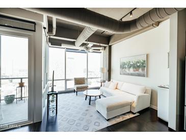 Bright living room with floor-to-ceiling windows and sleek, modern decor at 1 E Lexington Ave # 1306, Phoenix, AZ 85012