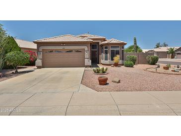 Charming single-story home features a desert landscaped front yard with a two car garage at 11038 W Oraibi Dr, Peoria, AZ 85373