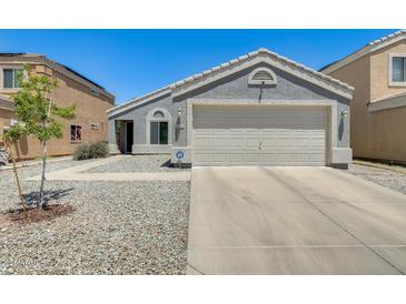Single story home features a two car garage, low maintenance yard, and neutral color scheme at 12318 W Bloomfield Rd, El Mirage, AZ 85335
