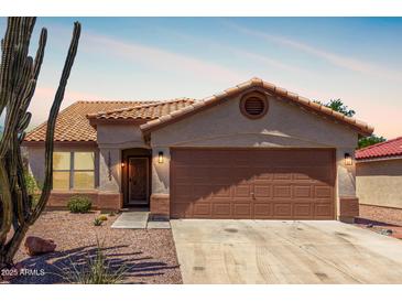 Charming single-story home with a well-maintained front yard, complemented by desert landscaping and a two car garage at 13862 W Fargo Dr, Surprise, AZ 85374