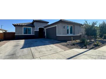 Charming single-story home featuring desert landscaping, a two-car garage, and a neutral color palette at 25968 W Tina Ln, Buckeye, AZ 85396