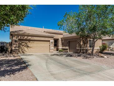 Charming single-story home featuring a three-car garage, desert landscaping, and a tile roof at 26264 N 74Th Ln, Peoria, AZ 85383
