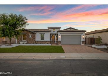 Stunning single-story home with stone accents, a paver driveway, and a lush front lawn at 3038 E Longhorn Dr, Gilbert, AZ 85297