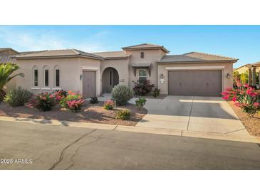 Charming, Southwestern-style home with a well-manicured lawn and a three-car garage at 41584 W Springtime Rd, Maricopa, AZ 85138