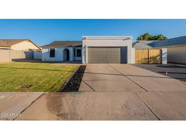 Charming home features a well-manicured lawn, neutral color palette, and a two-car garage at 4855 E Gary St, Mesa, AZ 85205