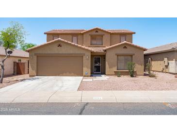 Two-story home boasts desert landscaping, a neutral color palette, and an attached two car garage at 6944 S Morning Dew Ln, Buckeye, AZ 85326