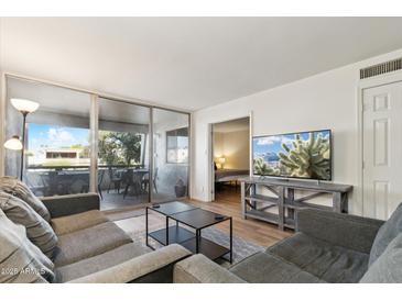 Inviting living room with a comfortable sofa, stylish coffee table, and a private balcony with great outdoor views at 7625 E Camelback Rd # B226, Scottsdale, AZ 85251