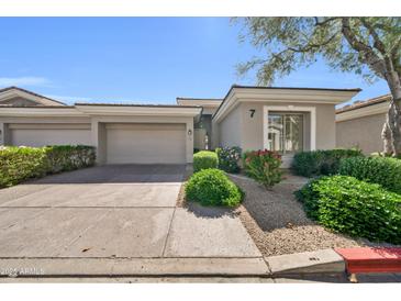Charming single-story home featuring a two-car garage, desert landscaping, and a neutral color palette at 8180 E Shea Blvd # 1019, Scottsdale, AZ 85260