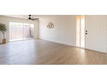 Spacious living room featuring new floors, ceiling fan, large sliding door, and ample natural light at 909 S Acapulco Ln # A, Tempe, AZ 85281