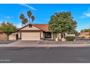 Charming single-story home with a well-maintained lawn, mature trees, and a two-car garage at 1001 N Nielson St, Gilbert, AZ 85234