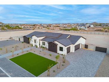 An aerial view captures the home's gray roof, modern exterior, driveway, landscaping, and neighborhood at 2005 W Lincoln Ct, Queen Creek, AZ 85144