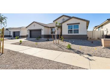 Charming single-story home with a well-manicured desert landscape and a two-car garage at 15357 W Cottontail Ln, Surprise, AZ 85387