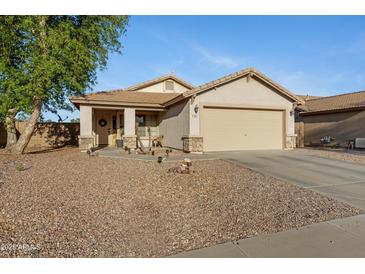 Charming single-story home featuring low maintenance desert landscaping and a neutral color palette at 1673 S 171St Dr, Goodyear, AZ 85338