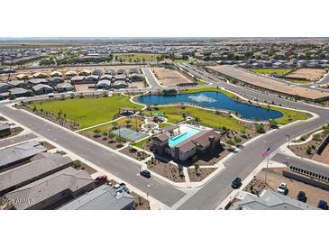 An aerial view showing a community pool, playground, and pond in a new neighborhood at 19195 N Los Gabrieles Way, Maricopa, AZ 85138