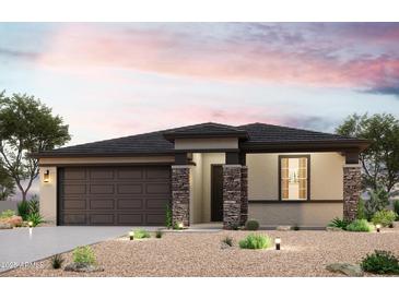 Charming single-story home featuring stone accents, a two-car garage, and desert landscaping at 19265 N Los Gabrieles Way, Maricopa, AZ 85138