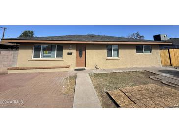 Charming single-story home featuring a neutral-toned exterior, well-maintained lawn, and inviting front entrance at 2724 W Highland Ave, Phoenix, AZ 85017